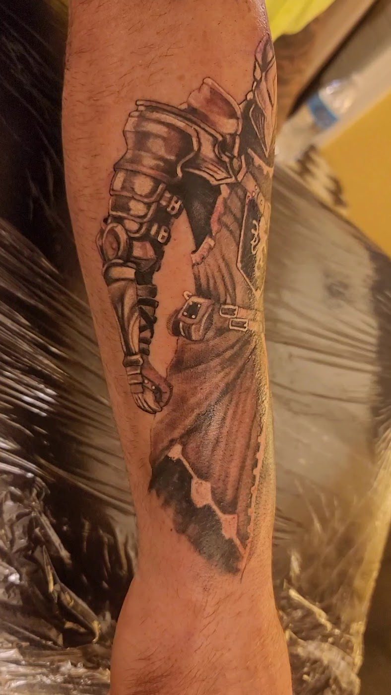 Detailed black and grey arm tattoo