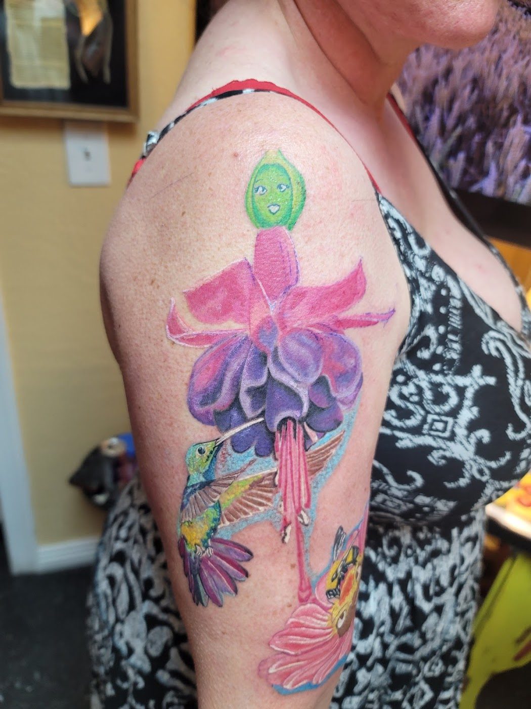 Vibrant color flower and hummingbird tattoo by Atomic Art Tattoo Studio in Nampa